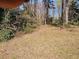 A peaceful and private backyard with a mix of open grassy area and natural trees, offering space for relaxation at 3685 Emily Way, Atlanta, GA 30349