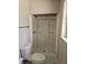Clean white bathroom with glass shower, toilet, and gray floor, bathed in natural light through the nearby window at 3685 Emily Way, Atlanta, GA 30349