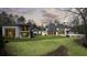 Sprawling backyard featuring a main house, guest house, covered patio, and lush landscaping at 5245 Kenbrook Way, Sandy Springs, GA 30327