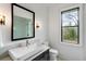 Bright bathroom featuring modern vanity with marble countertop and black frame window at 5245 Kenbrook Way, Sandy Springs, GA 30327