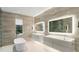 Luxurious bathroom with dual vanities, stone walls, accent lighting, and a modern soaking tub at 5245 Kenbrook Way, Sandy Springs, GA 30327