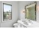 Elegant bathroom featuring a decorative mirror, marble countertop, and natural light from the window at 5245 Kenbrook Way, Sandy Springs, GA 30327