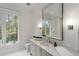 Bathroom with large vanity, generous mirror and bright lighting with a view of the outdoor greenery at 5245 Kenbrook Way, Sandy Springs, GA 30327