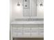 Stylish bathroom with a marble countertop, white cabinets, and modern light fixtures at 5245 Kenbrook Way, Sandy Springs, GA 30327