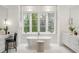 Modern bathroom with a soaking tub, dual vanity sinks, natural lighting and white fixtures at 5245 Kenbrook Way, Sandy Springs, GA 30327