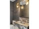 Chic powder room showcasing textured wallpaper, marble vanity, and decorative lighting at 5245 Kenbrook Way, Sandy Springs, GA 30327