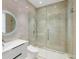 Modern bathroom with tiled walls, sleek vanity, round mirror, and a glass-enclosed shower with a rainfall showerhead at 5245 Kenbrook Way, Sandy Springs, GA 30327