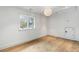 Bright, empty bedroom with hardwood floors, large window, white walls, and modern light fixture at 5245 Kenbrook Way, Sandy Springs, GA 30327