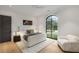 Modern bedroom with large window overlooking the yard, soft textures, and a cozy seating area at 5245 Kenbrook Way, Sandy Springs, GA 30327