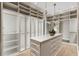 Walk-in closet with custom shelving, cabinets, and a center island with drawers at 5245 Kenbrook Way, Sandy Springs, GA 30327