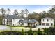 Elegant home featuring a gated entrance, manicured lawn, and a connected garage at 5245 Kenbrook Way, Sandy Springs, GA 30327