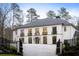 Stately two-story home featuring a gated entrance and a circular driveway, surrounded by mature trees at 5245 Kenbrook Way, Sandy Springs, GA 30327