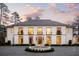 Elegant two-story home with a circular driveway and fountain, complemented by manicured landscaping at 5245 Kenbrook Way, Sandy Springs, GA 30327