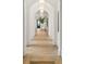 Bright hallway with herringbone-patterned wood floors, arched entryways and modern lighting fixtures at 5245 Kenbrook Way, Sandy Springs, GA 30327