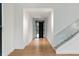 Long bright hallway featuring hardwood floors, a glass staircase, and a steel door at the end at 5245 Kenbrook Way, Sandy Springs, GA 30327