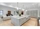 Open-concept kitchen with large marble island, pendant lights, breakfast bar, and seamless flow to the living area at 5245 Kenbrook Way, Sandy Springs, GA 30327