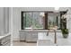 Bright kitchen with a large marble island, a view through an open window, and a gold faucet at 5245 Kenbrook Way, Sandy Springs, GA 30327