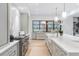 Bright kitchen with a large marble island, wooden floors, stainless steel stove, and stylish pendant lights at 5245 Kenbrook Way, Sandy Springs, GA 30327