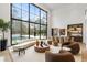 Spacious living room with a wall of windows, dining area, and modern furniture at 5245 Kenbrook Way, Sandy Springs, GA 30327