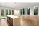 Bright living room featuring hardwood floors, large windows, and a modern island with countertop seating at 5245 Kenbrook Way, Sandy Springs, GA 30327