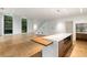 Open-concept living room with hardwood floors, a modern kitchen island, and staircase to the second floor at 5245 Kenbrook Way, Sandy Springs, GA 30327