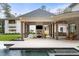 Covered patio with a fireplace, outdoor kitchen, and views of the pool and backyard at 5245 Kenbrook Way, Sandy Springs, GA 30327