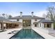 Exterior of home features a large in-ground pool and access to covered outdoor living spaces at 5245 Kenbrook Way, Sandy Springs, GA 30327