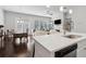 Open-concept living space with kitchen island, dining area, and living room with fireplace at 5726 Taylor Way, Sandy Springs, GA 30342