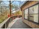 Long wood deck featuring wood railings and exterior of home with many trees surrounding at 595 Overbrook Nw Dr, Atlanta, GA 30318