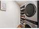 Laundry area featuring a stacked washer and dryer unit, and additional shelving at 595 Overbrook Nw Dr, Atlanta, GA 30318
