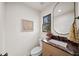 Stylish powder room featuring a marble countertop, oval mirror, and modern fixtures at 595 Overbrook Nw Dr, Atlanta, GA 30318