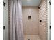 Updated shower with neutral tiled walls, a shower curtain, and modern fixtures at 595 Overbrook Nw Dr, Atlanta, GA 30318