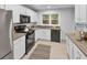 Modern kitchen boasts stainless steel appliances, white cabinetry, and sleek countertops for a clean aesthetic at 656 Channing Nw Dr, Atlanta, GA 30318