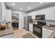 Bright kitchen featuring white cabinets, modern appliances, and a view of the dining area at 656 Channing Nw Dr, Atlanta, GA 30318
