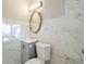 Modern bathroom with marble-style tile, a gray vanity, and an ornate mirror at 1672 Thornton Pl, Atlanta, GA 30315