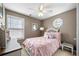 Bedroom with ceiling fan, octagon window, and a bed with pink bedding at 331 Greystone Pkwy, Hiram, GA 30141