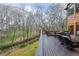 Relaxing deck with beautiful views of a creek and the woods; furnished with comfortable seating and a fire pit at 275 Tynebrae Pl, Roswell, GA 30075