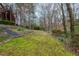 Expansive backyard featuring lush greenery, mature trees, and landscaping on a sloped lot at 275 Tynebrae Pl, Roswell, GA 30075