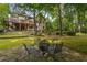 Secluded backyard with a stone patio and firepit for outdoor entertainment, surrounded by lush greenery and trees at 275 Tynebrae Pl, Roswell, GA 30075