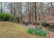 Picturesque backyard featuring a creek, mature trees, play set and stone patio with fire pit at 275 Tynebrae Pl, Roswell, GA 30075