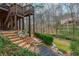 Landscaped backyard with stone steps leading to a creek and home with multi-level deck above at 275 Tynebrae Pl, Roswell, GA 30075