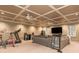 Finished basement with large sectional sofa, coffered ceiling and lights, plus gym area for workouts at 275 Tynebrae Pl, Roswell, GA 30075