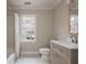 Bathroom features a bathtub with tile surround, vanity with a large mirror, and natural lighting at 275 Tynebrae Pl, Roswell, GA 30075