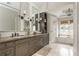 Bathroom with dual vanities, and a soaking tub by a large window at 275 Tynebrae Pl, Roswell, GA 30075