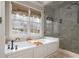 Bathroom with a soaking tub, a shower with a glass door, and a large window at 275 Tynebrae Pl, Roswell, GA 30075