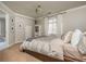 Neutral bedroom features a comfy bed, a window with white curtains, and a bookshelf at 275 Tynebrae Pl, Roswell, GA 30075