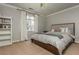 Neutral bedroom features a comfy bed, a window with white curtains, and a built-in bookshelf at 275 Tynebrae Pl, Roswell, GA 30075