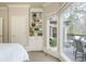Bedroom boasts white built in shelves with decorations, and a large picture window overlooking the backyard deck at 275 Tynebrae Pl, Roswell, GA 30075