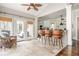 Charming breakfast area adjacent to the kitchen, featuring travertine floors, a bar, and views of the deck at 275 Tynebrae Pl, Roswell, GA 30075