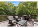 A spacious deck surrounded by lush greenery, featuring a dining table and comfortable seating for outdoor entertaining at 275 Tynebrae Pl, Roswell, GA 30075